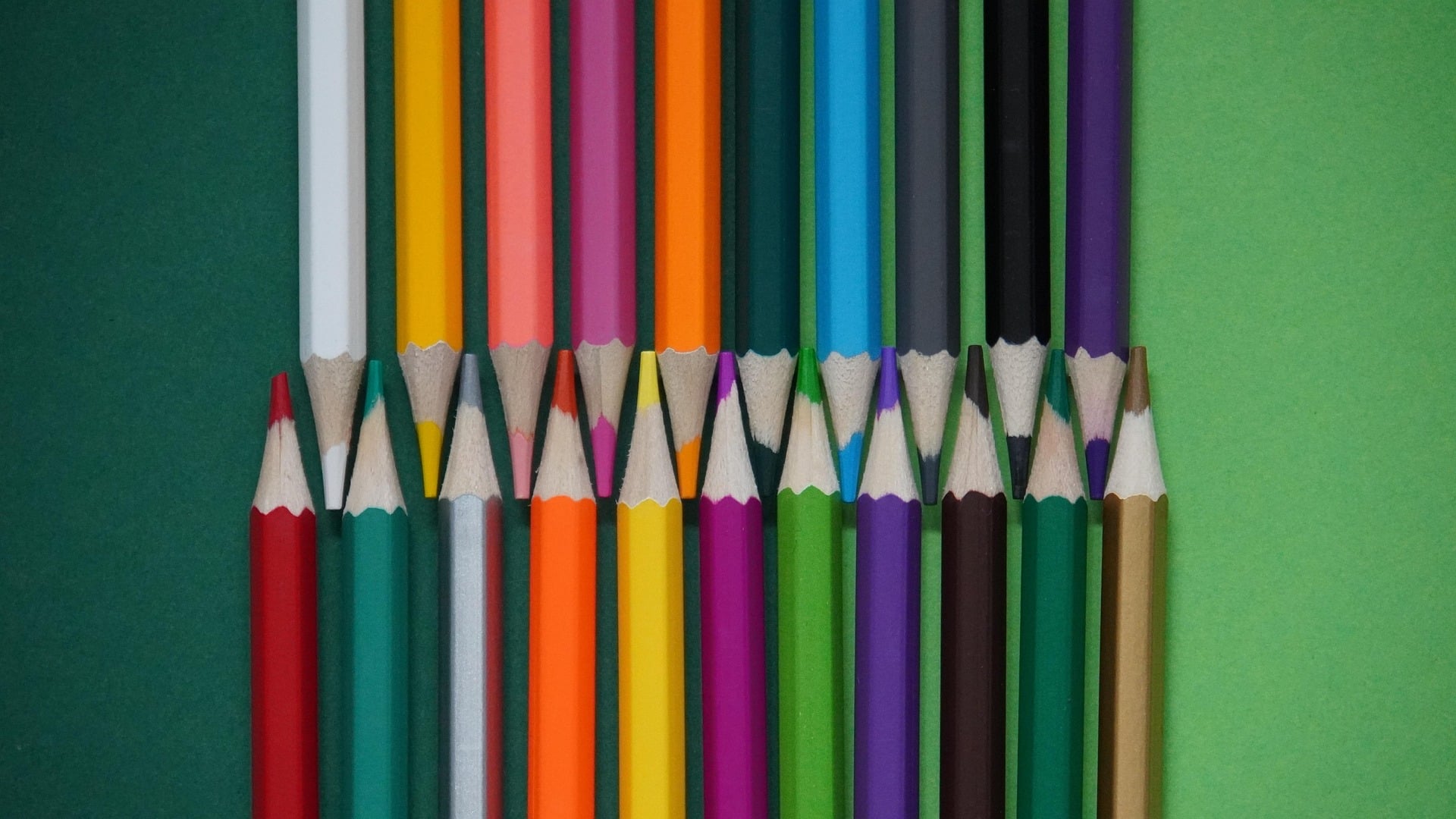 Kleurpotloden in verschillende kleuren liggen op een effen achtergrond