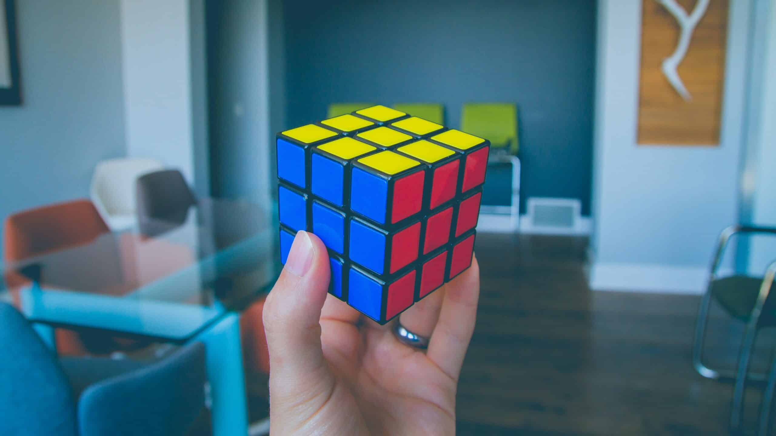 Eén hand houdt een opgeloste Rubik's kubus vast
