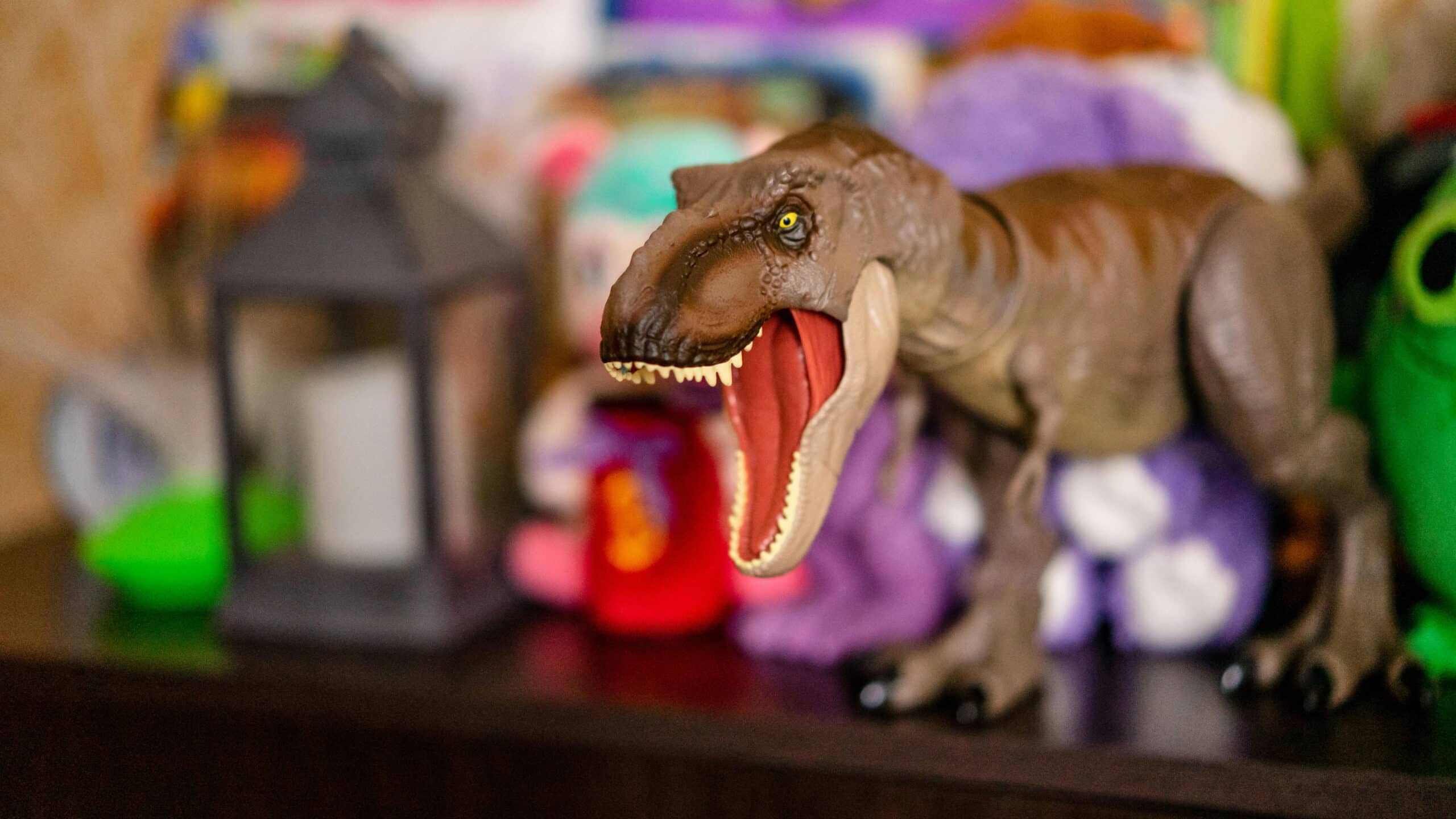 Een dinosaurus met zijn bek open in de slaapkamer van een kind.