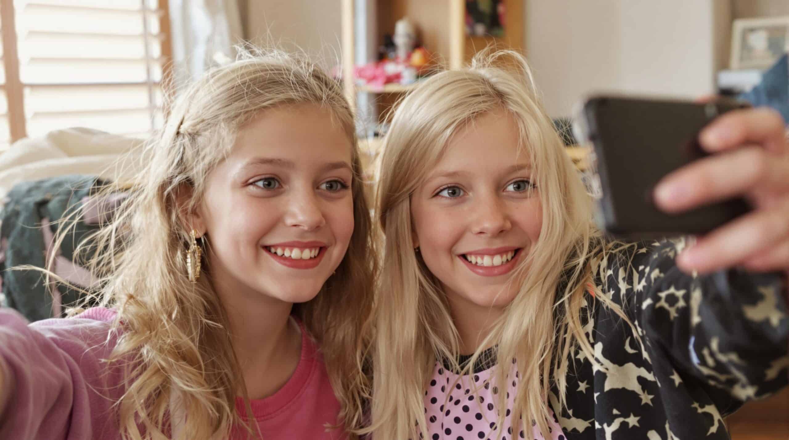 Twee meisjes nemen een selfie met hun smartphone