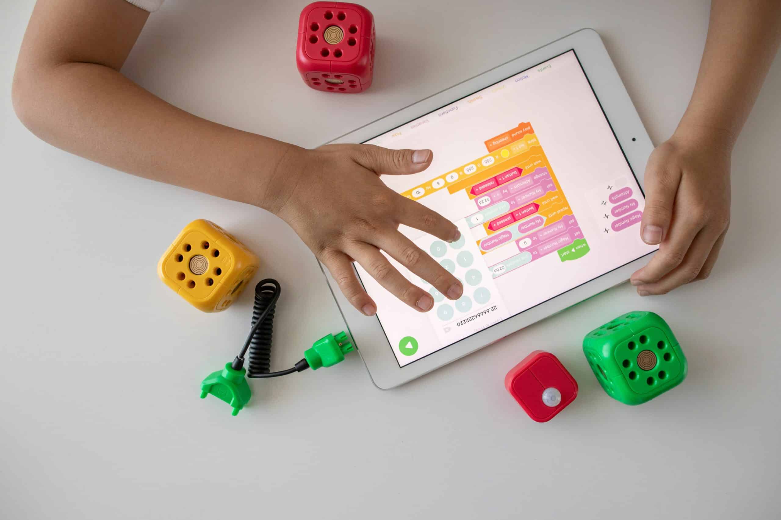 Een kind programmeert op een tablet met een kindvriendelijke app.
