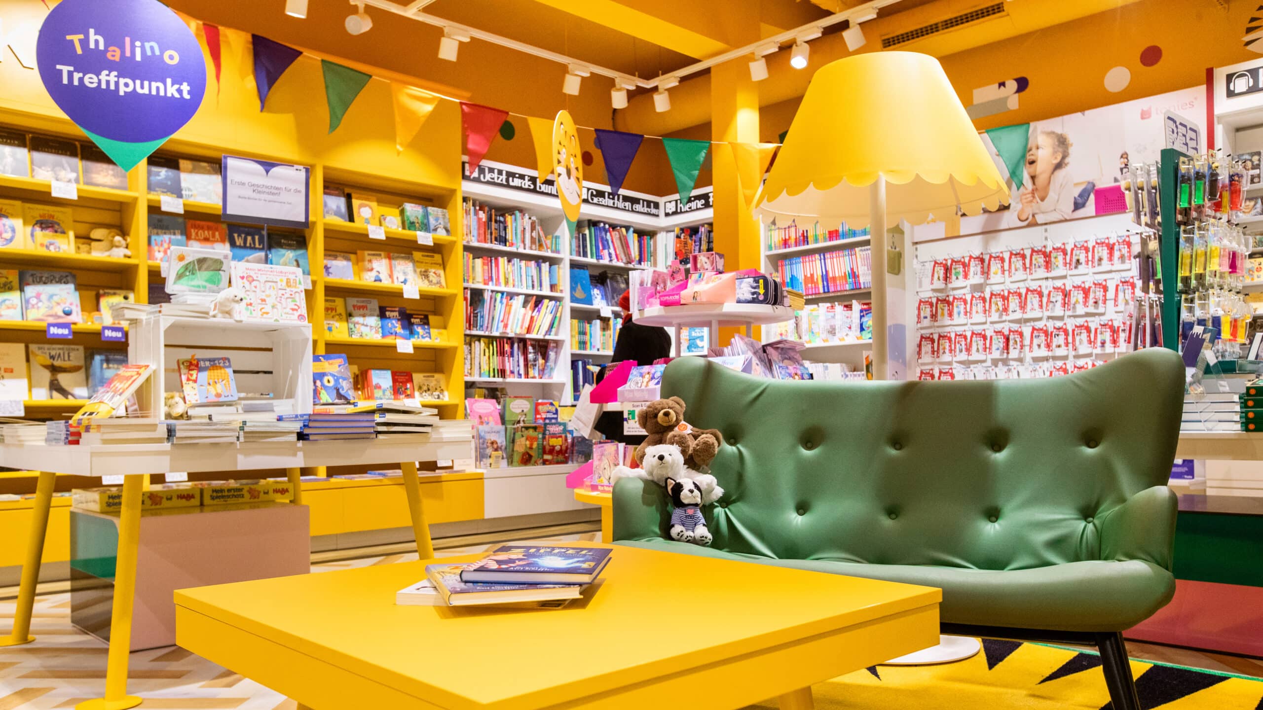 Een Thalino-ontmoetingspunt in een Thalia-winkel met een tafel, bank en veel boeken op de achtergrond